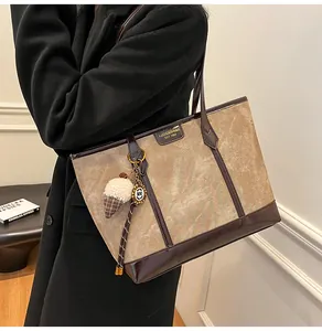 Détail d'un sac cabas en PU marron clair avec plaque métallique et pendentif de crème glacée