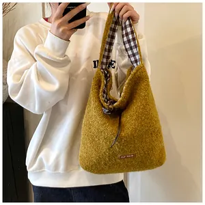 Detail of mustard yellow plush tote bag with checkered lining and faux leather brand tag
