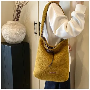 Detail of ginger plush tote bag with leather logo tag and contrast check fabric lining