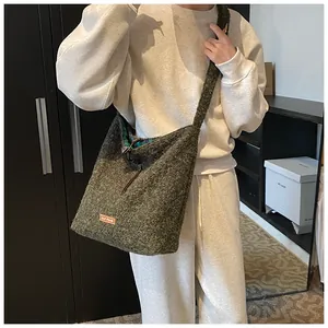 Detail showing moss green tweed texture and stylish inner check lining of the tote bag