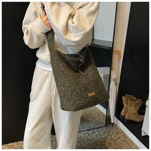 Detailed view of olive green plush tote bag featuring drawstring closure and textured fabric