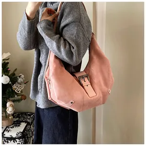 Detail of pink suede hobo bag featuring silver buckle and durable stitching