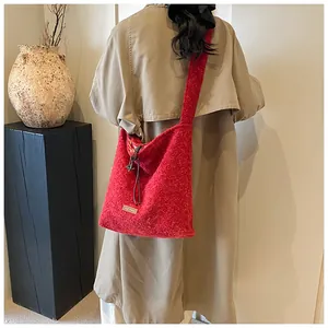 Detail of red wool tote bag with drawstring closure and brand label shown in retro setting