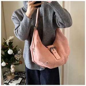 Detail showing pink suede hobo bag with large buckle and rivet accents in a lifestyle setting