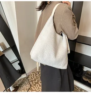 Detailed side view of large white faux shearling hobo bag with slim shoulder straps