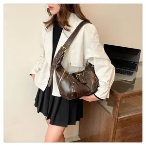 Detail der dunkelbraunen Hobo-Tasche mit Vintage-Goldnieten und verstellbaren Riemen
