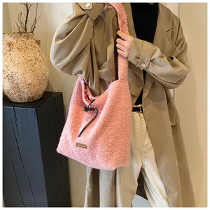 Detailed close-up of pink plush tote bag with lamb wool texture and faux leather logo