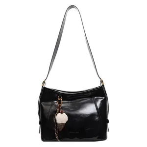 Glossy black oil-wax leather shoulder tote bag with a plush ice cream charm decoration