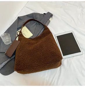 Detail of soft brown faux shearling tote bag with leather strap and zip pouch