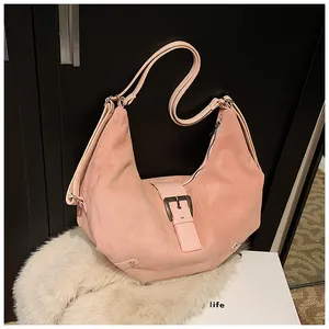 Detailed macro of pink suede hobo bag with moon shape design and leather buckle detail