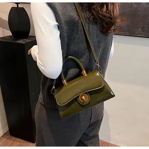 Detail showing an olive green patent leather bag with a gold twist lock and shoulder strap