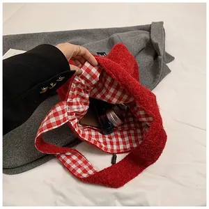 Detail of red plush tote bag showing internal red and white checkered lining compartment