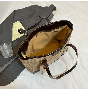 Vue détaillée du sac cabas en similicuir marron avec poche zippée et pendentif doux