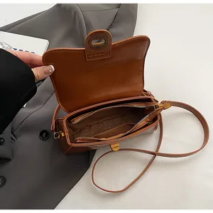 Detail view of the brown leather bag interior showing compartments and zipper pocket