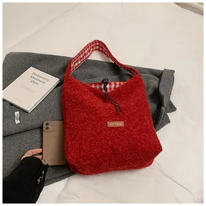 Close-up of red plush tote bag showing check lining and our fave leather label detail