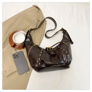 Detailansicht der dunkelbraunen Hobo-Tasche mit goldenen Nieten und Lederstruktur im Set