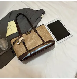 Détail d'un grand sac cabas avec garniture en cuir synthétique marron et breloque pompon