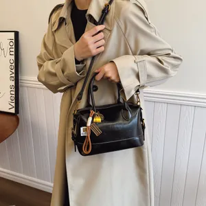 Classic black Boston bag with glossy finish, gold hardware and adjustable strap