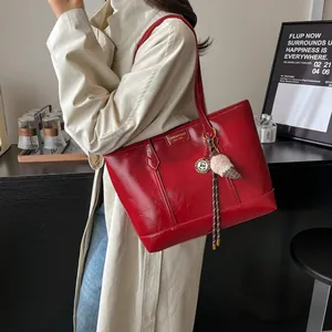 Grand sac cabas rouge en cuir synthétique brillant avec logo et pendentif