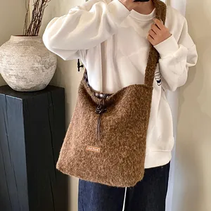 Brown fuzzy sherpa tote bag with drawstring closure and our fave label shown on model