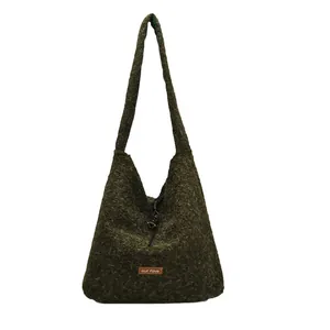 Dark green plush tote bag with furry texture and brown leather patch in hobo style