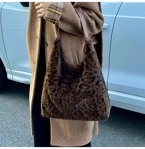 Detailed side view of leopard print plush hobo bag with brown leather strap worn by a model