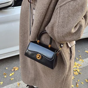 Retro black leather trapezoid handbag with gold hardware and top handle for women