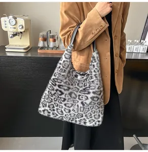 Detailed view of leopard print faux fur tote bag with black leather straps in lifestyle setting