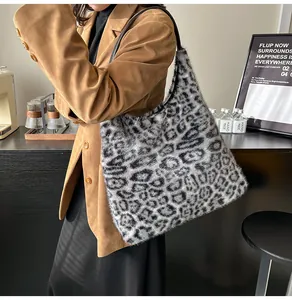 Close-up of leopard faux fur tote bag with black leather straps on a stylish model