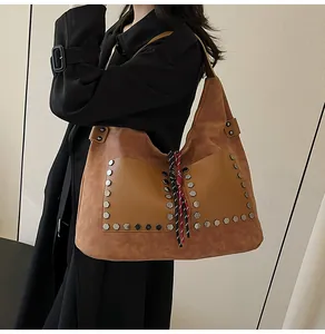 Detail of vintage tote bag with silver hexagonal rivets and tricolor woven rope decoration