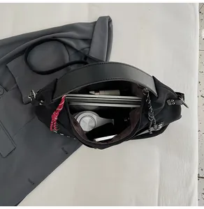 Spacious interior of black bucket bag showing a laptop and headphones for commute