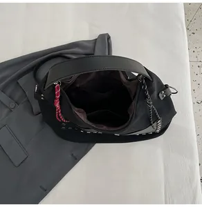 Interior detail of large black bucket bag showing spacious compartments and rivets