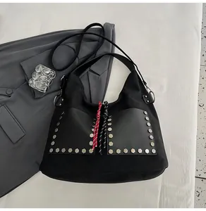 Detail of black matte tote bag featuring silver rivet studs and double front patch pockets