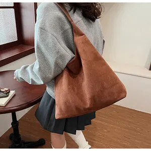 Large brown suede tote bag shown on model for a minimalist oversized hobo look