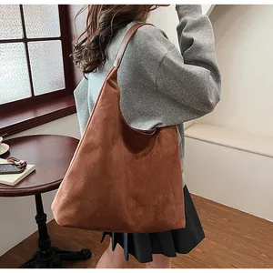 Brown suede hobo tote bag shown on shoulder for large capacity daily commute