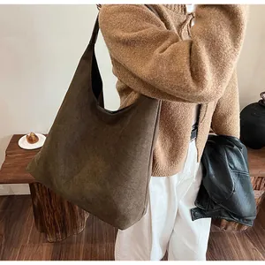 Detail shot of a dark brown suede hobo tote bag featuring a spacious minimalist design
