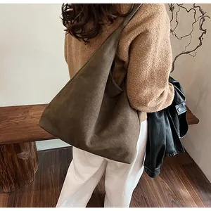 Macro detail of the dark coffee suede tote bag showing premium texture and shoulder fit