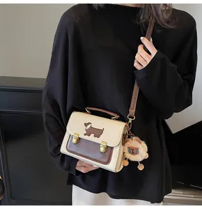 Detail of a retro contrast shoulder bag featuring dachshund embroidery and plush charm