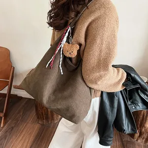 Winter large capacity tote bag in brown canvas with cute plush bear charm on model