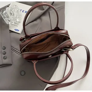 Innenansicht der braunen Lackleder-Handtasche mit Reißverschlussfach und Textilfutter
