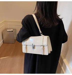 Vue détaillée du sac à bandoulière crème avec fermoir rotatif argenté et boucles en métal