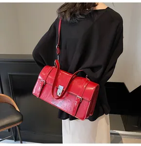 Vue détaillée du sac bandoulière en cuir verni rouge brillant avec boucle et fermoir