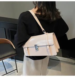 Gros plan d'une sacoche vintage rose pâle avec boucle argentée et finition en cuir lisse