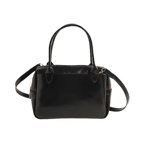 Minimalistische schwarze Handtasche aus Glanzleder mit Henkeln und Gurt