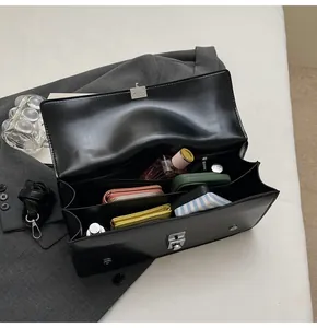 Vue de dessus de l'intérieur du sac avec plusieurs compartiments et fermoir argent