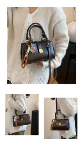 Detail of vintage dark brown faux leather handbag with metal buckle and pink charm