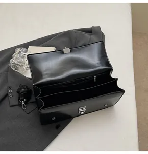 Détails de l'intérieur multi-compartiments et fermoir rotatif argenté sur sac à main noir