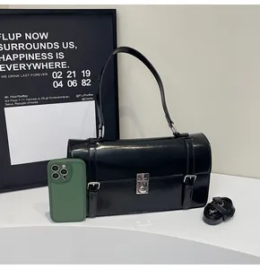 Détail du sac bandoulière en cuir noir brillant avec boucle argentée et téléphone inclus