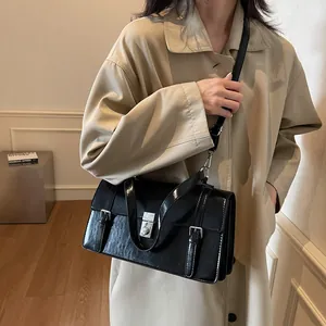 Sac messager en cuir verni noir brillant avec fermoir argenté et doubles boucles