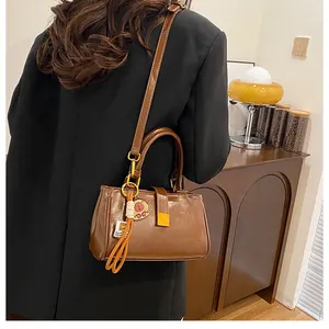 Detailed macro view of vintage brown leather handbag with a cute bear tassel charm accessory